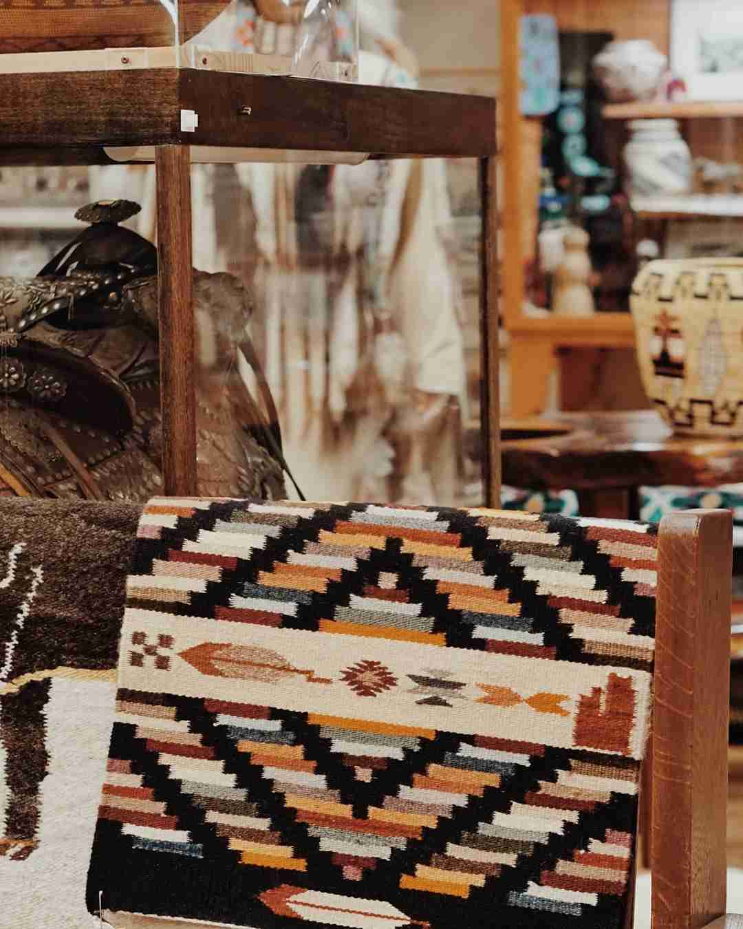 Southwestern woven rugs displayed inside rustic trading post
